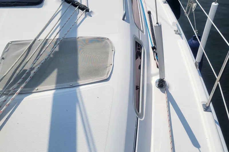 Slide: The Image of 2009 Hunter 38 sailboat deck with ropes and hatch, docked on calm water. - 48
