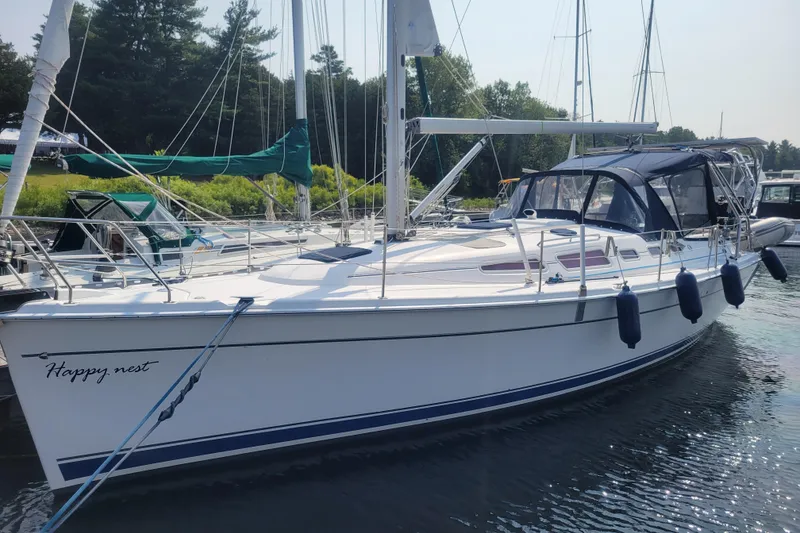 Slide: The Image of 2009 Hunter 38 sailboat docked, featuring sleek design and blue fenders. - 52