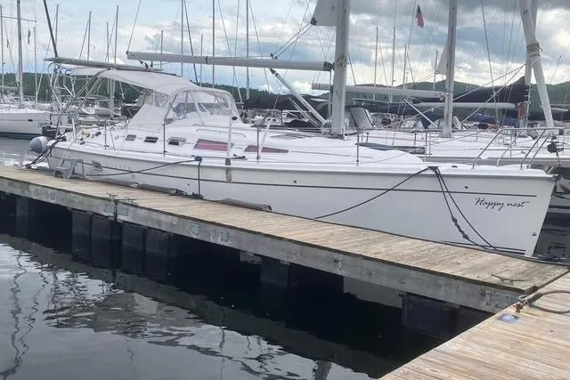 Slide: The Image of 2009 Hunter 38 sailboat docked at marina, overcast sky, calm water. - 55