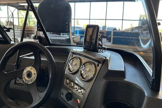 Slide: The Image of 2026 Tracker Pro Guide V-16 WT boat dashboard with steering wheel and gauges. - 4