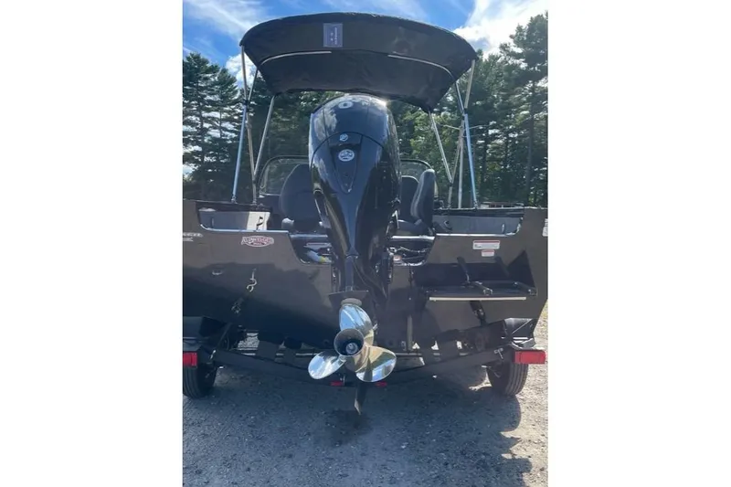 Slide: The Image of 2026 Tracker Targa V-18 WT boat with outboard motor, parked outdoors. - 7