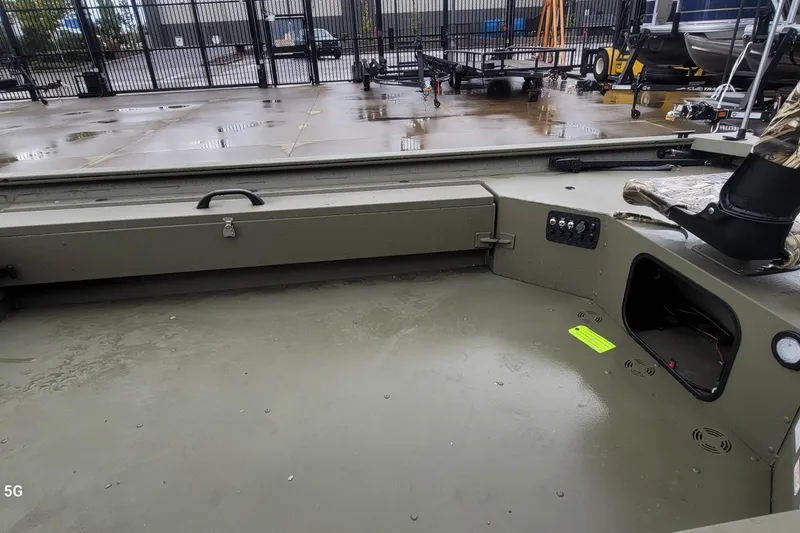 Slide: The Image of 2026 Tracker Grizzly 1654 T Sportsman boat interior with storage and control panel. - 2