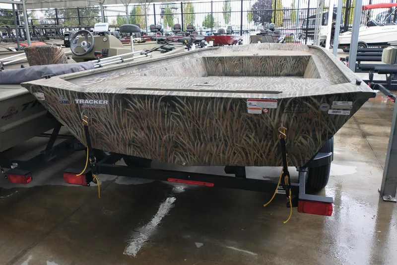 Slide: The Image of 2026 Tracker GRIZZLY 1860 Utility boat with camouflage design on a trailer. - 2