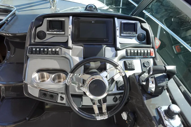 Slide: The Image of Control panel of a 2016 Monterey 355 Sport Yacht with steering wheel and navigation displays. - 12