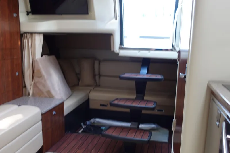 Slide: The Image of Interior of 2016 Monterey 355 Sport Yacht with wooden steps and beige seating. - 21