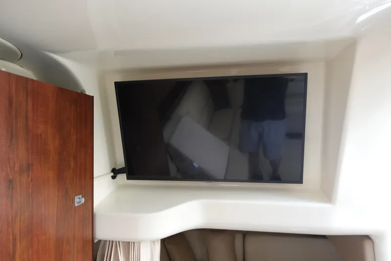 Slide: The Image of Flat-screen TV in 2016 Monterey 355 Sport Yacht interior, next to wooden cabinet. - 23