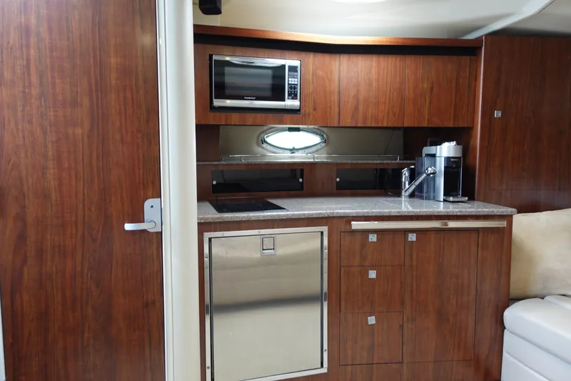 Slide: The Image of Interior of 2016 Monterey 355 Sport Yacht with modern kitchenette and wood cabinetry. - 24