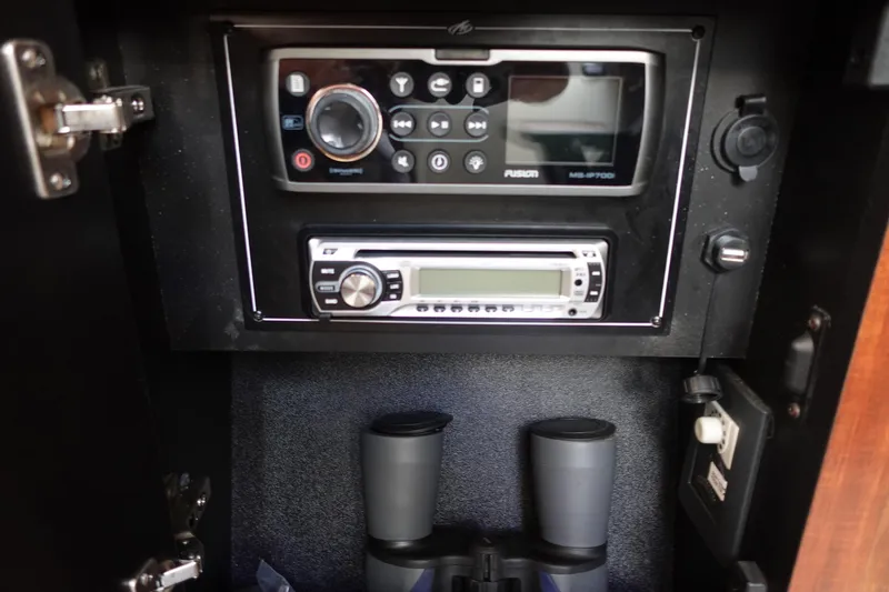 Slide: The Image of Control panel and binoculars inside a 2016 Monterey 355 Sport Yacht cabinet. - 33