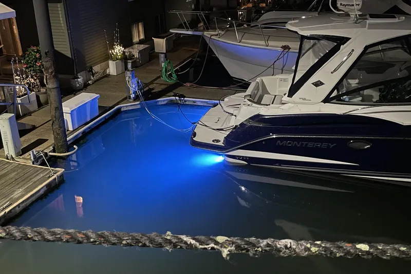Slide: The Image of 2016 Monterey 355 Sport Yacht docked with blue underwater lights at night. - 8