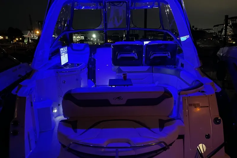 Slide: The Image of Illuminated interior of a 2016 Monterey 355 Sport Yacht at night, featuring blue ambient lighting. - 9