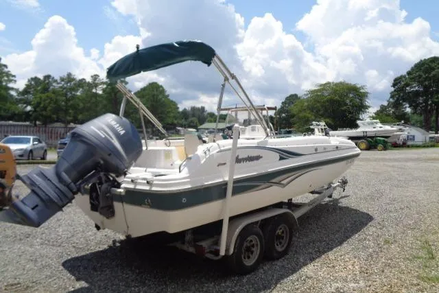 The Image of 2005 Hurricane GS211 boat with Yamaha outboard motor on a trailer, parked outdoors. - 0