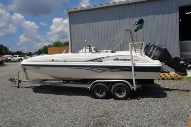 Slide: The Image of 2005 Hurricane GS211 boat on trailer, parked outdoors near a metal building. - 10