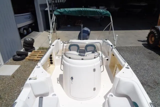 Slide: The Image of 2005 Hurricane GS211 boat with green canopy and dual seating in a storage area. - 18