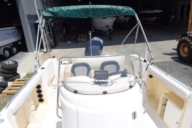 Slide: The Image of 2005 Hurricane GS211 boat with green canopy and dual seating in a storage area. - 24