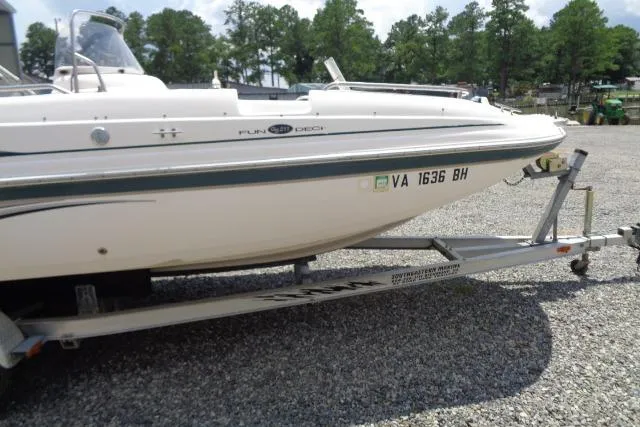 Slide: The Image of 2005 Hurricane GS211 boat on trailer, parked on gravel with trees in background. - 5