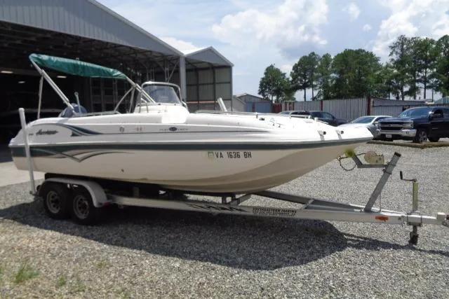 Slide: The Image of 2005 Hurricane GS211 boat on trailer, parked outdoors near a warehouse. - 6