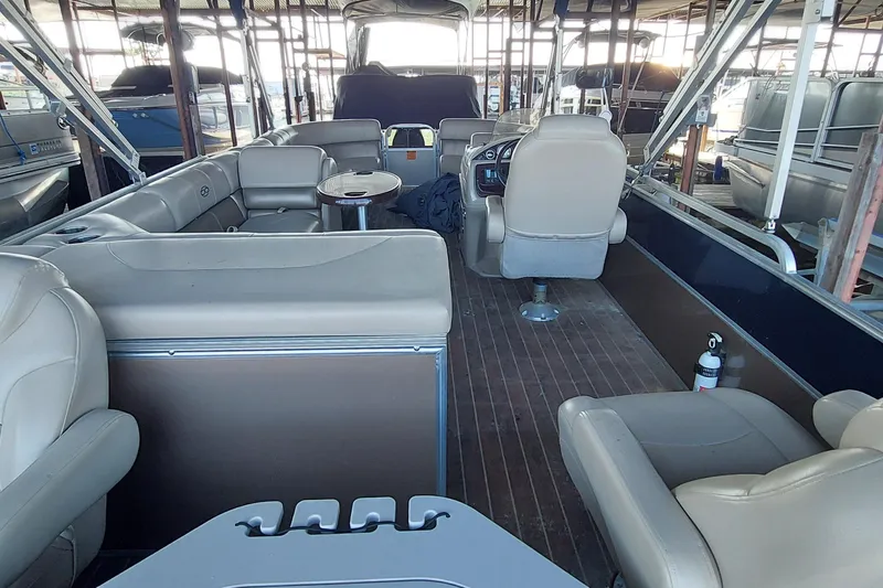 Slide: The Image of Interior of 2015 Xcursion 23RFC pontoon boat with beige seating and wooden flooring. - 3