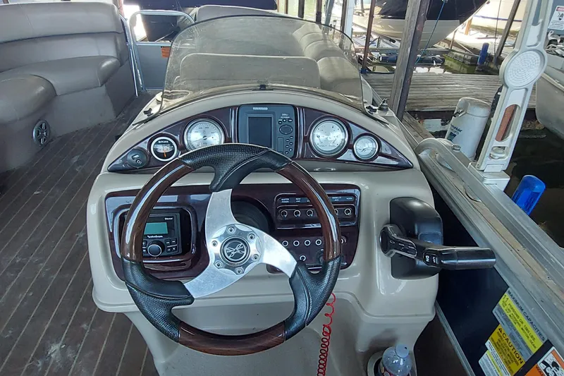 Slide: The Image of 2015 Xcursion 23RFC boat dashboard with steering wheel and control panel. - 4
