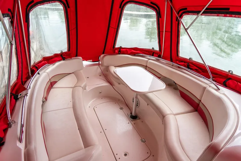 Slide: The Image of Interior of 1999 Chaparral 252 Sunesta boat with red canopy and beige seating. - 10