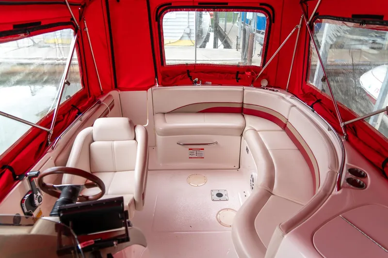 Slide: The Image of 1999 Chaparral 252 Sunesta boat interior with red canopy and white seating. - 19