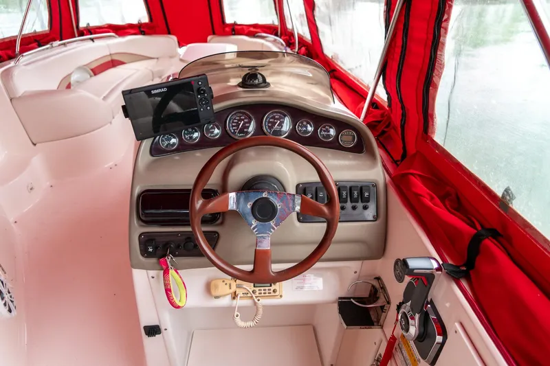 Slide: The Image of 1999 Chaparral 252 Sunesta boat cockpit with red canopy and steering wheel. - 7