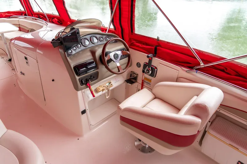 Slide: The Image of 1999 Chaparral 252 Sunesta boat interior with red accents and steering console. - 8