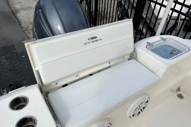 Slide: The Image of 2020 Cobia 201 Center Console boat seating and storage area with cup holders. - 21