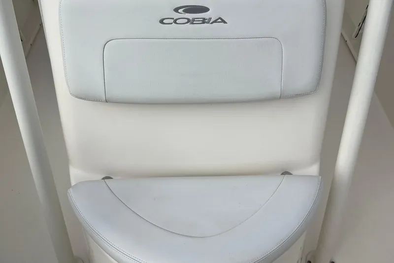 Slide: The Image of Cobia 201 Center Console 2020 boat seat with logo, white upholstery. - 7
