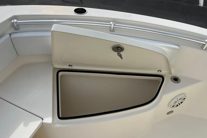 Slide: The Image of 2020 Cobia 201 Center Console boat storage compartment with open hatch and key. - 9