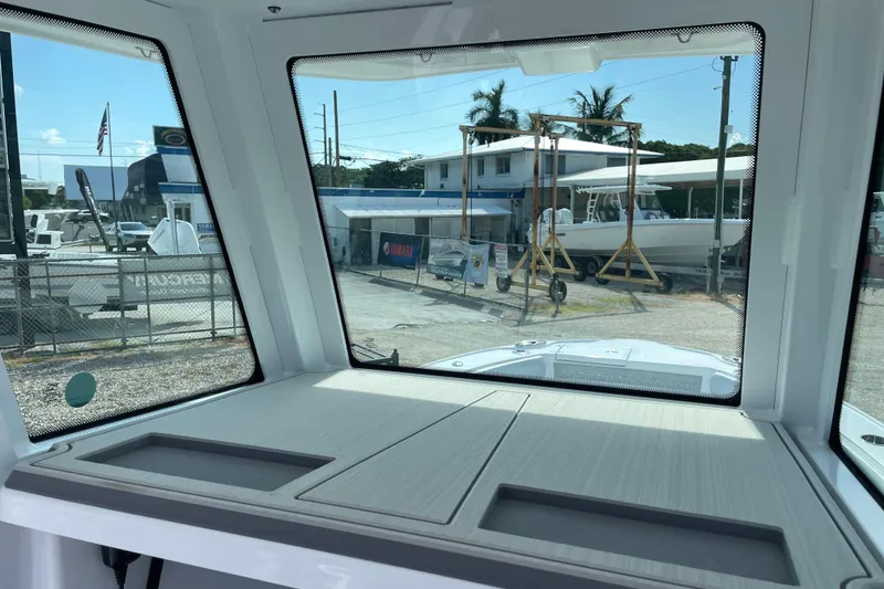 Slide: The Image of Interior view from a 2026 Blackfin 242HB boat, overlooking a marina with boats. - 18