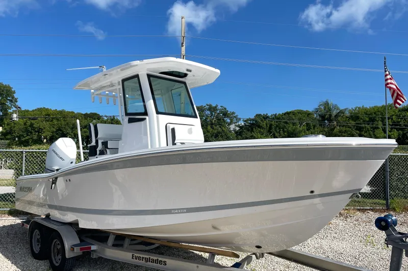 Slide: The Image of 2026 Blackfin 242HB boat on trailer, clear sky background, American flag visible. - 2