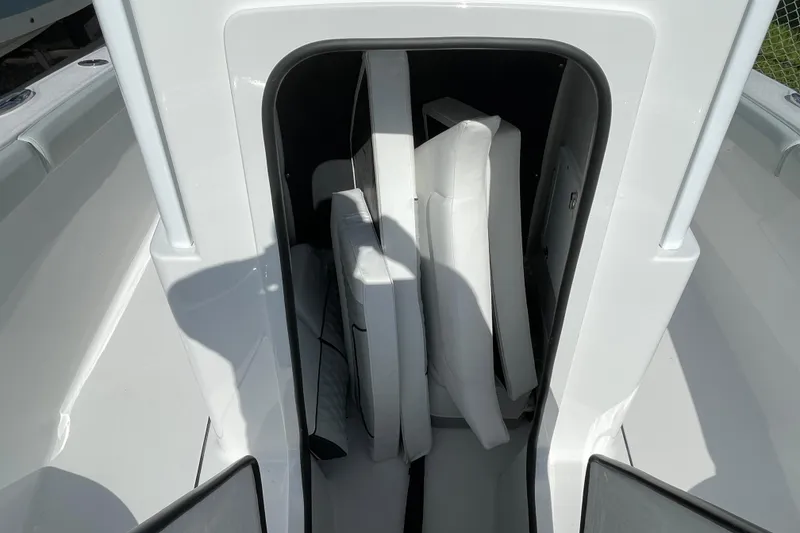 Slide: The Image of Storage compartment on 2026 Blackfin 242HB boat with white cushions inside. - 25