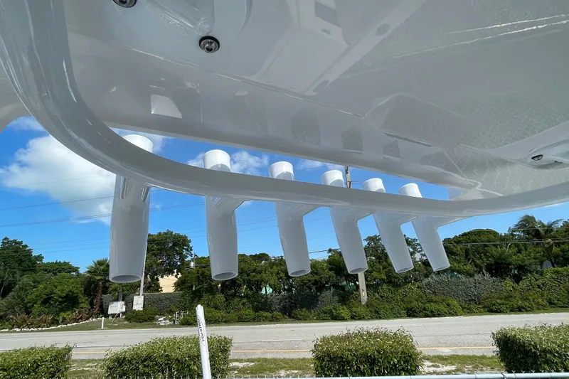 Slide: The Image of Underside view of 2026 Blackfin 242HB boat with rod holders against blue sky. - 28