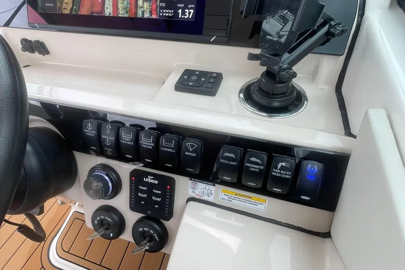 Slide: The Image of Control panel of 2023 Boston Whaler 280 Vantage boat with various switches and displays. - 43
