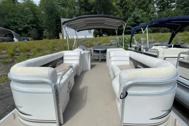 Slide: The Image of 2002 Godfrey Aqua Patio 2424DF pontoon boat with white seating and canopy, docked outdoors. - 4