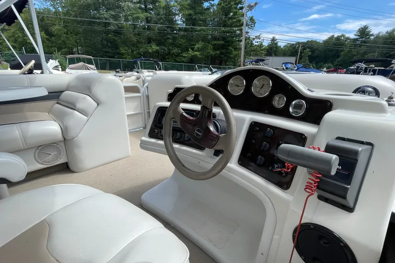 Slide: The Image of Interior of 2002 Godfrey Aqua Patio 2424DF boat with steering wheel and dashboard controls. - 5