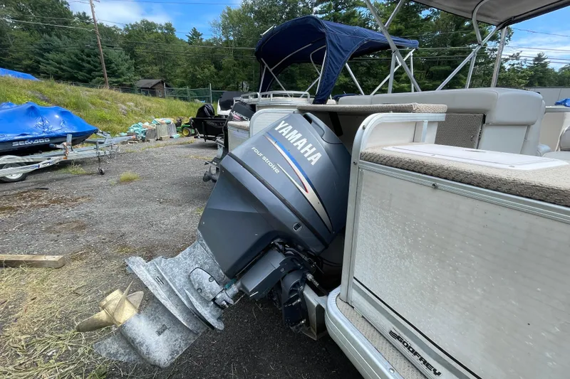 Slide: The Image of 2002 Godfrey Aqua Patio 2424DF with Yamaha outboard motor in a yard setting. - 7