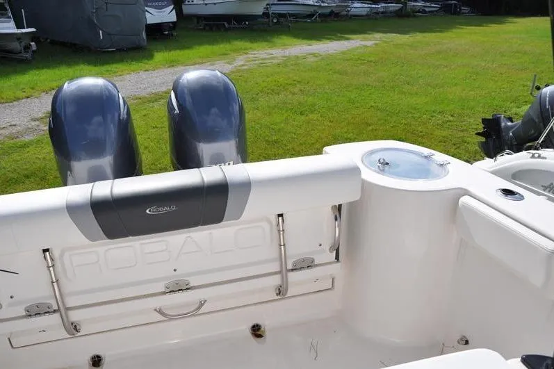 Slide: The Image of 2023 Robalo R272 Center Console boat with dual engines, outdoor setting. - 10