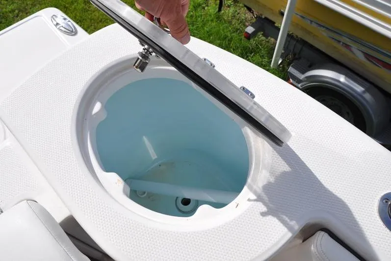 Slide: The Image of 2023 Robalo R272 Center Console livewell with open lid, showcasing interior design. - 11