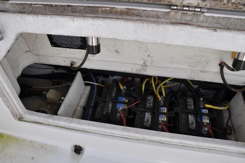 Slide: The Image of 2023 Robalo R272 Center Console boat battery compartment with wiring and connections. - 12
