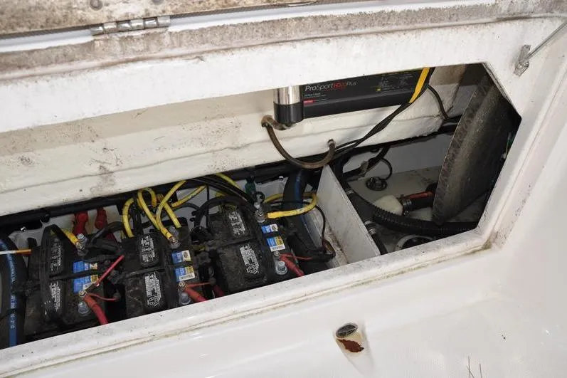 Slide: The Image of 2023 Robalo R272 Center Console battery compartment with wiring and charger. - 13