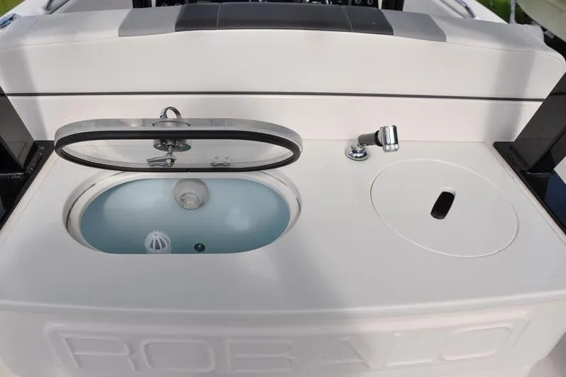 Slide: The Image of 2023 Robalo R272 Center Console boat with livewell and sink features. - 14