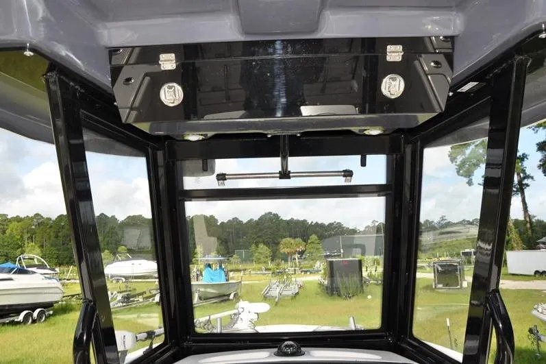 Slide: The Image of 2023 Robalo R272 Center Console boat interior with overhead storage and clear view. - 16