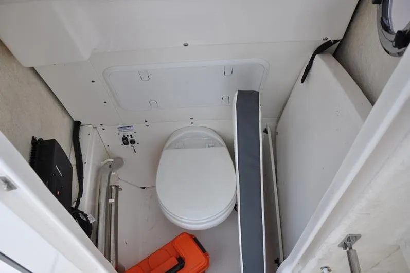 Slide: The Image of 2023 Robalo R272 Center Console boat interior with toilet and storage area. - 29