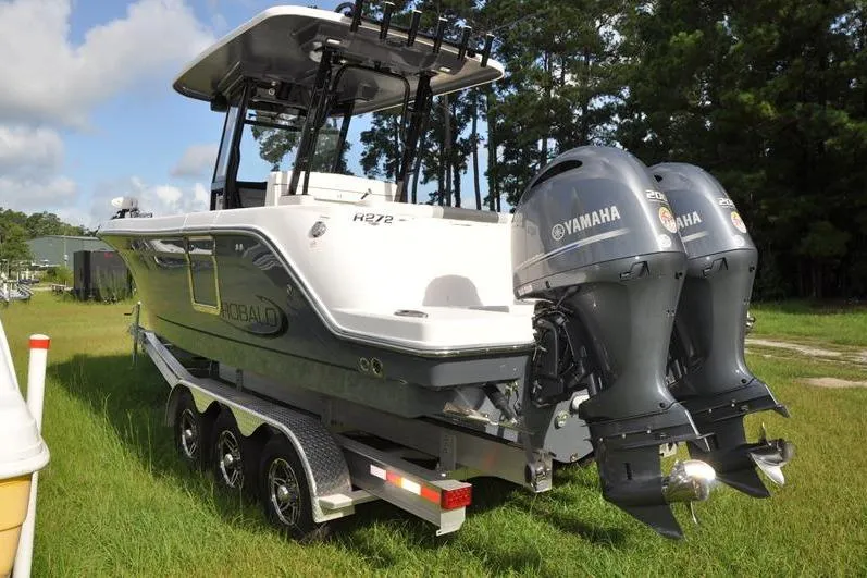 Slide: The Image of 2023 Robalo R272 Center Console boat with dual Yamaha engines on a trailer. - 3
