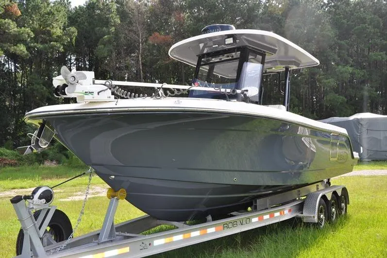 Slide: The Image of 2023 Robalo R272 Center Console boat on trailer in grassy area. - 4