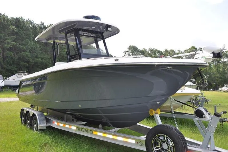 Slide: The Image of 2023 Robalo R272 Center Console boat on trailer, parked on grass. - 6