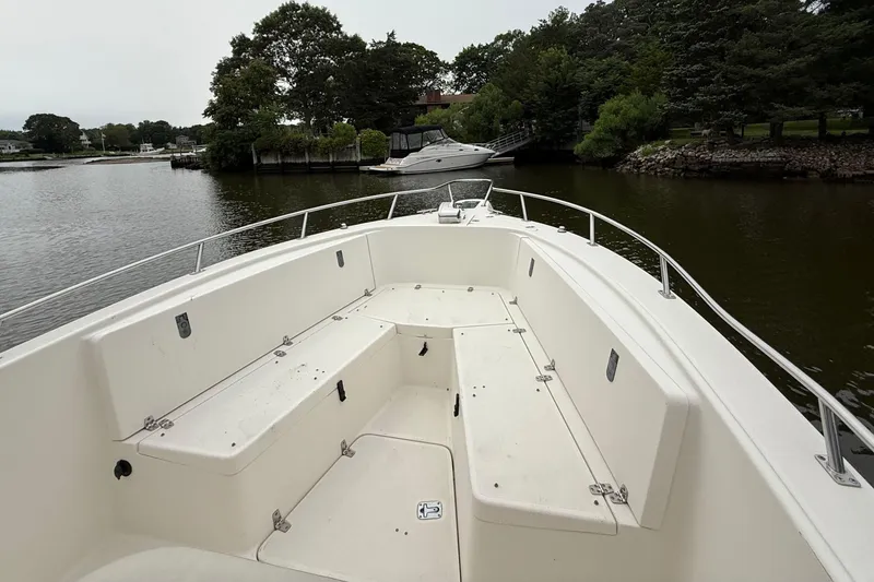 Slide: The Image of 2008 Pursuit C 280 Center Console boat interior with seating, docked on a calm river. - 16