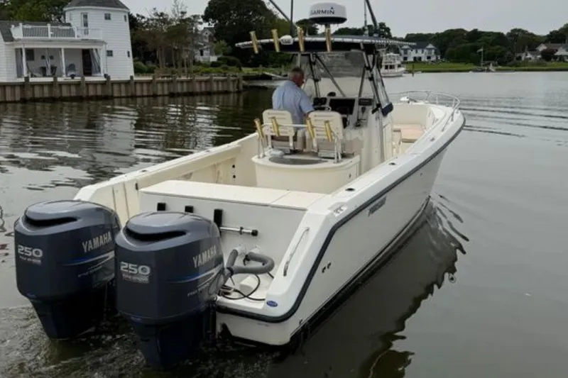Slide: The Image of 2008 Pursuit C 280 Center Console boat with twin Yamaha engines on a calm lake. - 6