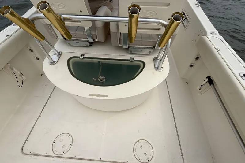 Slide: The Image of 2008 Pursuit C 280 Center Console boat interior with rod holders and livewell. - 8